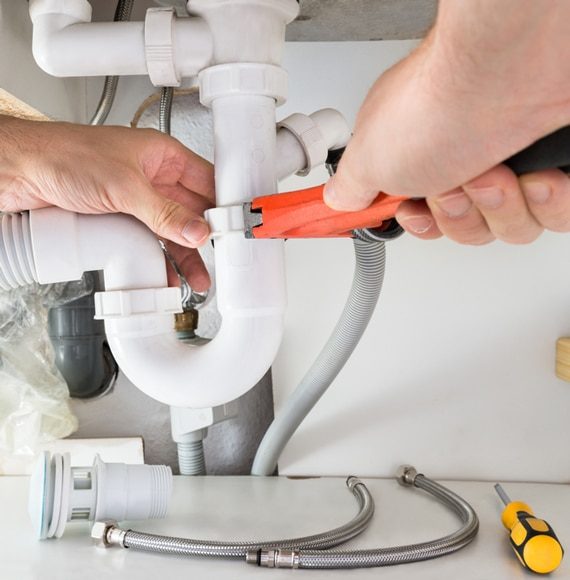 Male Plumber Fixing Sink — Murphy Plumbing In Newcastle, NSW